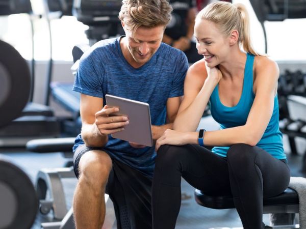 personal trainer e aluna conversando na academia