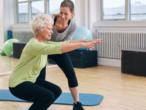 personal trainer mostrando movimento para a cliente